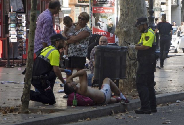 epa06148659 Mossos d'Esquadra Police officers attend injured people after a van crashed into pedestrians in Las Ramblas, downtown Barcelona, Spain, 17 August 2017. According to initial reports a van crashed into a crowd in Barcelona's famous Placa Catalunya square at Las Ramblas area injuring several. Local media report the van driver ran away, metro and train stations were closed. The number of people injured and the reasons behind the incident are not yet known. Official sources have not confirmed that the incident is a terrorist attack. EPA/David Armengou FACE PIXELATED BY SOURCE DUE TO LOCAL LAW