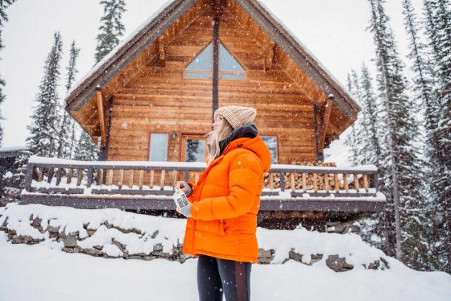 Γυναίκα με πορτοκαλί μπουφάν στα χιόνια